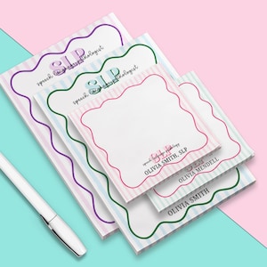 May include: A stack of personalized notepads with a scalloped border and striped background in pink, blue, and green. The notepads feature the text "SLP speech language pathologist" and individual names.