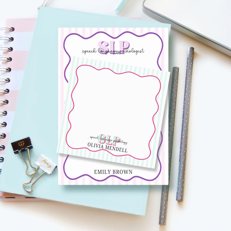 May include: A notepad and sticky note set with a striped background and scalloped edges. The notepad has the text "SLP speech language pathologist" and the sticky note has the text "SLP OLIVIA MENDELL" and "EMILY BROWN". A notebook, pencils, and paper clips are also visible.