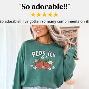 May include: Green sweatshirt with a graphic of two strawberries and the text "PEDS ICU" in white.
