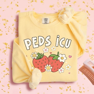 May include: Yellow sweatshirt with a graphic of two strawberries and the text "PEDS ICU".