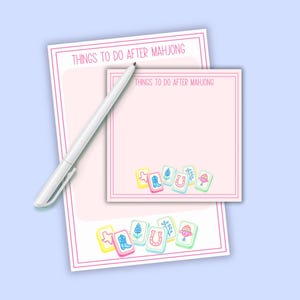 May include: A light pink notepad and sticky note set with the text "THINGS TO DO AFTER MAHJONG" in a playful font. The set includes a white pen and colorful Mahjong tile illustrations.