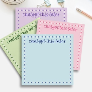 May include: Four colorful sticky notes in pastel shades of lavender, pink, green, and blue. Each note has a dotted border and the text "chatgpt this later" in a handwritten style font. Office supplies are in the background.