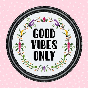 May include: White embroidery hoop with a floral wreath design and the text "GOOD VIBES ONLY" in black lettering.