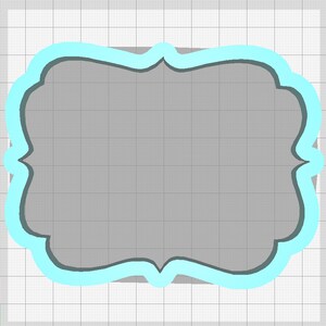 May include: A light blue decorative frame with a scalloped edge. The frame is on a gray background.