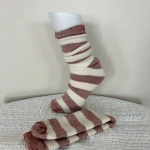 May include: A pair of white and rust-coloured striped socks. The socks are made of a soft, cosy material and are perfect for keeping your feet warm in the winter.