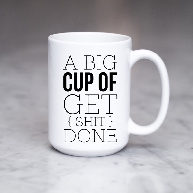 May include: White ceramic coffee mug with black text that reads "A big cup of get {shit} done".