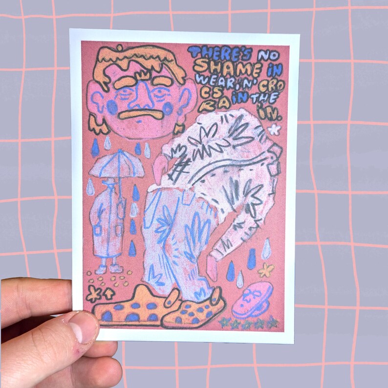 K&ouml;nnte beinhalten: Eine handgezeichnete Illustration einer Person, die ein gemustertes Hemd und eine blaue Jeans tr&auml;gt, mit dem Text "THERE'S NO SHAME IN WEARIN' CROCS IN THE RAIN." Die Person tr&auml;gt gelbe und schwarze Crocs und h&auml;lt einen Regenschirm. Der Hintergrund ist rosa.