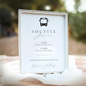 Puede incluir: Un letrero blanco enmarcado con texto negro y un icono de autobús. El letrero dice "SHUTTLE Service" con horarios y ubicaciones para un servicio de transporte gratuito. Los nombres "Madison and Henry" están en la parte inferior.