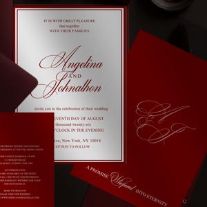 May include: Elegant wedding invitation suite in burgundy and white. The main invitation features the names "Angelina and Johnathon" in a flowing script. Additional cards include RSVP and details, with a promise inscription.