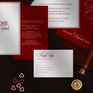 May include: Elegant wedding invitation suite in burgundy and silver. Includes invitation, RSVP card, and details card. Features ornate calligraphy and a wax seal. The text reads "Joshua and Danielle" and "Kindly Reply".