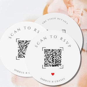 May include: Two white round cards with black text that says "SCAN TO RSVP" and "SCAN TO RS" with a QR code on each card. The text "THE FINER DETAILS" is on the top of one card. The text "JORDAN & CHANEL" is on the bottom of each card.