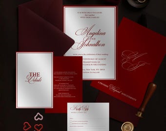 May include: A wedding invitation suite in burgundy and silver, featuring an invitation, RSVP card, and details card. The invitation includes the names "Angelina and Johnathon". Gold wedding rings and a ring box are also present.