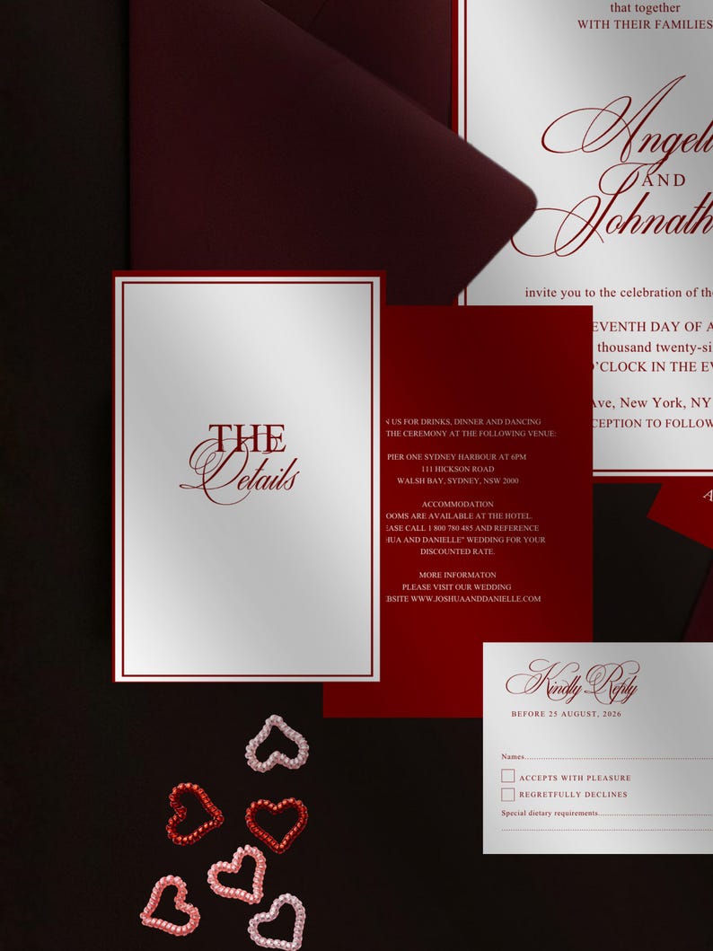 May include: A wedding invitation suite with a burgundy and white color scheme. The suite includes an invitation, RSVP card, and details card. Decorative heart-shaped embellishments are scattered around the cards.