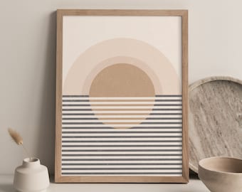 May include: A framed print with a geometric design featuring a large brown circle with concentric rings of light pink and white, set against a background of alternating gray and white stripes.