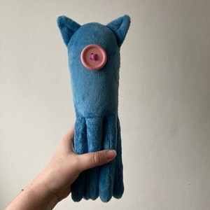 May include: A blue plush octopus toy with a pink button for an eye.