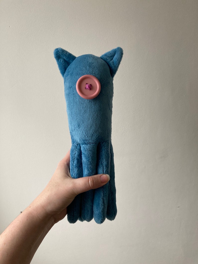 May include: A blue plush octopus toy with a pink button for an eye.
