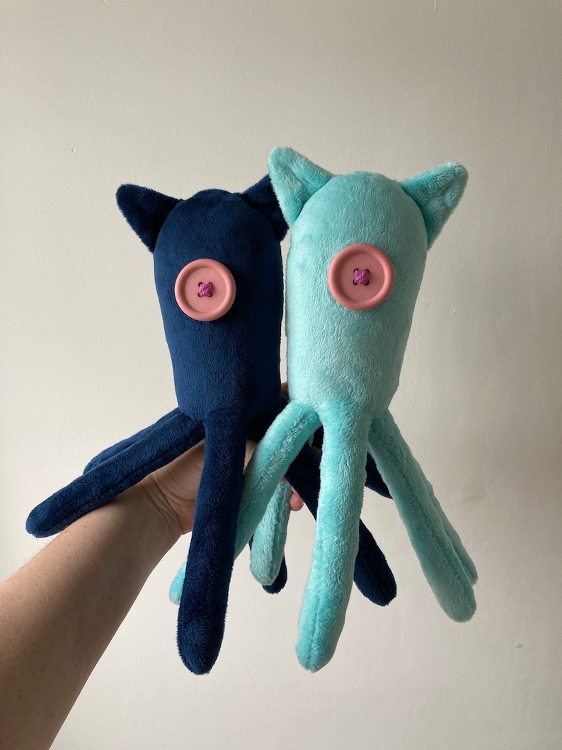 May include: Two plush octopus toys, one blue and one light blue, with pink button eyes.