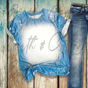 May include: A blue t-shirt with a white bleach design. The shirt is made of a soft, comfortable material and has a relaxed fit.