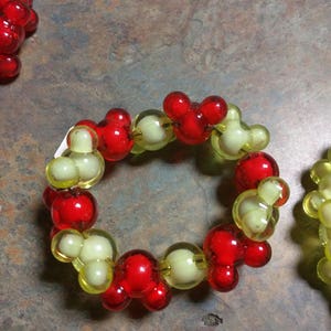 May include: A red and yellow beaded bracelet with Mickey Mouse head shaped beads.