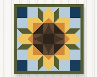 May include: A square, framed quilt block featuring a stylized sunflower design. The sunflower has yellow petals, a brown center, and green accents, set against a light blue and navy blue background. The frame is a dark green.