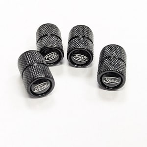 May include: Set of four black metal valve stem caps with the Ford logo in silver.