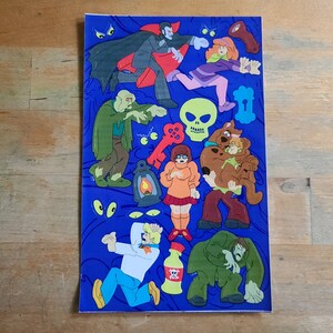 May include: A blue background with a variety of stickers featuring characters from the Scooby-Doo cartoon. The stickers include Scooby-Doo, Shaggy, Daphne, Velma, and a vampire. There are also stickers of a skull, a key, and a lantern.