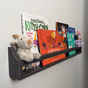 May include: A rustic wooden sign with the text "Welcome to our home" in a handwritten style. The sign features a distressed finish and a simple, inviting design, perfect for a front porch or entryway.