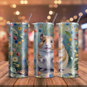 May include: Three stainless steel tumblers with a floral design and a hamster illustration. The hamster is brown and white with a happy expression. The tumblers are a great way to enjoy your favorite beverage.