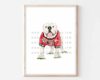 Könnte beinhalten: Aquarellmalerei eines weißen Bulldogs, der ein rot-schwarzes Trikot der University of Georgia mit dem Teamlogo und dem SEC-Logo trägt. Der Bulldog steht auf einem grünen Grasfleck.