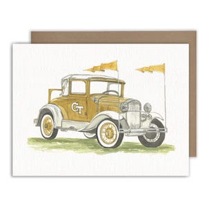 May include: A watercolor illustration of a vintage gold and white car with the letters GT on the side door. The vehicle features two tall poles with yellow pennant flags attached, white-walled tires, and is positioned on a patch of green grass.