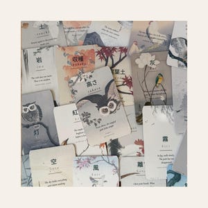 May include: A collection of rectangular cards featuring Japanese kanji characters, English translations, and illustrations of owls, birds, flowers, and landscapes. Each card displays a specific word like takasa, iwa, or sora, accompanied by descriptive text.