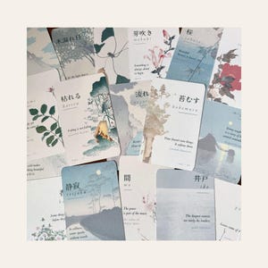 May include: A collection of rectangular cards featuring Japanese kanji characters, English definitions, and watercolor-style illustrations of nature, landscapes, and floral motifs in muted blue, green, and pink tones with white backgrounds.