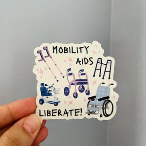 May include: A sticker featuring illustrations of mobility aids, including crutches, a walker, a scooter, and a wheelchair. The words "MOBILITY AIDS" and "LIBERATE!" are written on the sticker.