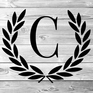 May include: Black and white image of the letter C surrounded by a laurel wreath on a woodgrain background.
