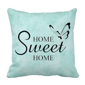 May include: A light blue throw pillow with a black butterfly and the text "Home Sweet Home" printed on it.