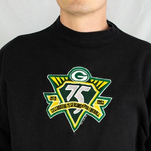 Puede incluir: Sudadera negra con un parche bordado verde y amarillo con el logotipo de los Green Bay Packers y el texto "Celebrating 75 Seasons of Professional Football 1919-1993".
