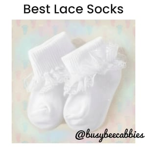 May include: A pair of white ankle socks featuring a ribbed cuff and a delicate lace ruffle trim. The text "Best Lace Socks" is printed at the top, and the handle "@busybeecabbies" is visible at the bottom against a background of footprints.