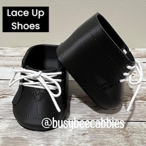 May include: A pair of black shoes with white laces and a lace-up design. The text "Lace Up Shoes" appears in a black box in the upper left corner, and the text "@busybeecabbies" is printed in white across the bottom of the image.