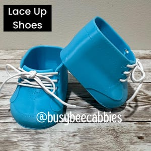 May include: A pair of bright blue shoes with white laces and a smooth finish. The text "Lace Up Shoes" is visible in a black box in the upper left corner, and the text "@busybeecabbies" is printed in white across the bottom of the image.