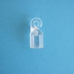 May include: A clear plastic hook for hanging items. The hook is approximately 2.5 cm long and has a small, rectangular base.