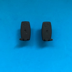 May include: Two black plastic hooks with the letters "RH" and "LH" printed on them.