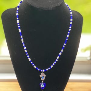 Beaded necklace with evil eye and hamsa pendant