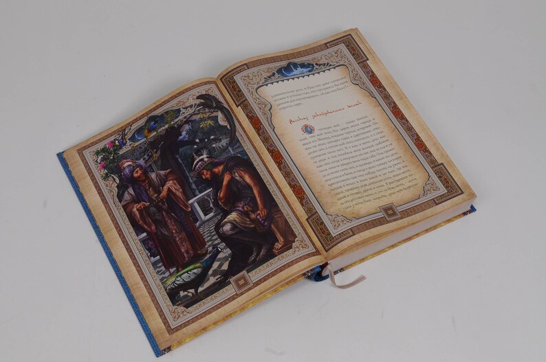 May include: An open book with colorful illustrations and text. The left page features a detailed painting of figures in ornate clothing, a peacock, and a garden setting. The right page has text within a decorative border.