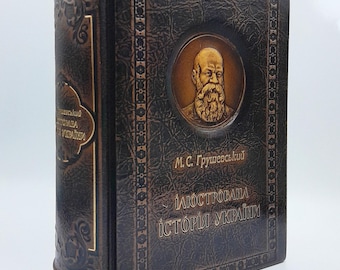 May include: A dark brown leather-bound book with a textured finish and gold-toned lettering. The cover features a circular embossed portrait of a bearded man, with the text M.C. Grushevsky and Illustrated History of Ukraine in Ukrainian.