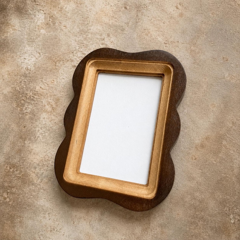 May include: A rectangular picture frame with a wavy, scalloped outer edge. The frame features a dark brown outer border and a lighter, natural wood-toned inner border surrounding a plain white rectangular center display area.