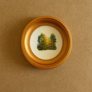 May include: A small, round watercolor painting of a forest scene, framed in a gold-colored, circular frame. The artwork depicts trees in shades of green, yellow, and orange, with a soft, naturalistic style. The frame is approximately 5 inches in diameter.