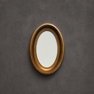 May include: An oval-shaped picture frame with a metallic gold finish and a smooth, rounded inner border. The frame features a wide, slightly concave profile that slopes inward towards a plain, white, oval-shaped centre insert for display.