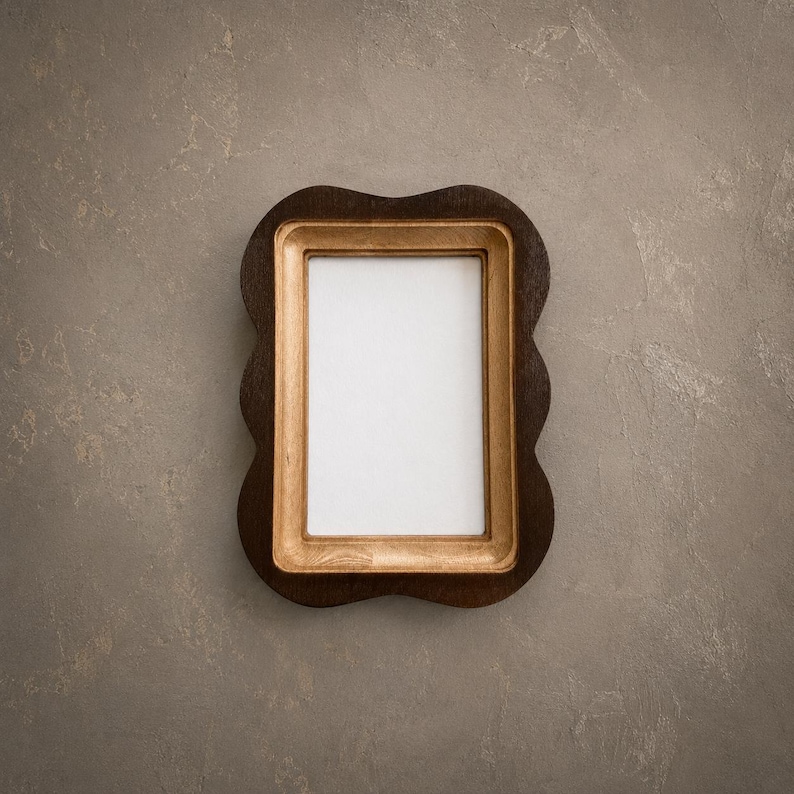 May include: A rectangular picture frame featuring a dark brown outer border with a scalloped edge and a light tan inner border. The frame surrounds a plain white rectangular center area, presenting a clear contrast between the two wood tones.