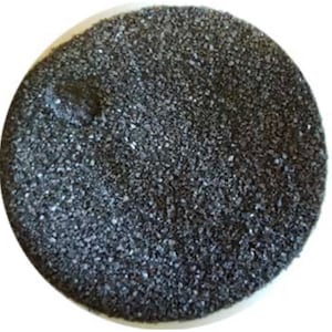 May include: A close-up view of a pile of black salt crystals. The salt is coarse and has a rough texture.