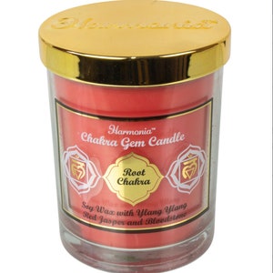 May include: A red soy wax candle with a gold lid and label. The label says "Harmonia™ Chakra Gem Candle" and "Root Chakra". The candle also includes red jasper and bloodstone.